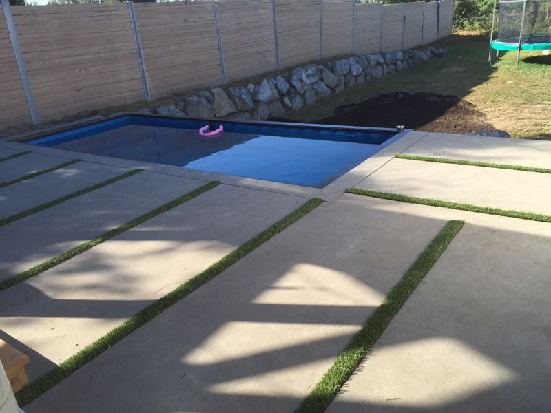 Close up of grass strips in concrete pool deck